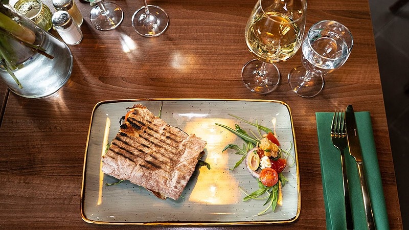 Draufsicht auf ein serviertes Steak mit Weißwein im JuBo