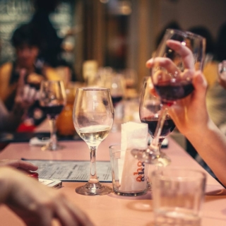 Tisch mit Menschen die beim Speed Dating Wein trinken