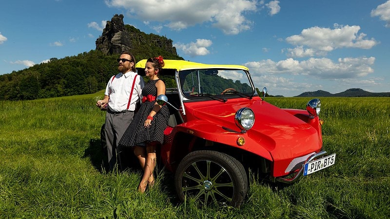 Paar steht vor Filmbuggy, Schnitzeljagd mit dem Filmbuggy Bud Spencer und Terence Hill