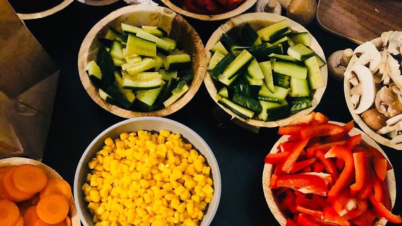 Business Bowl für Familien und Gruppen - Zutaten wie Gurke und Mais und Paprika in jeweils einer Schüssel