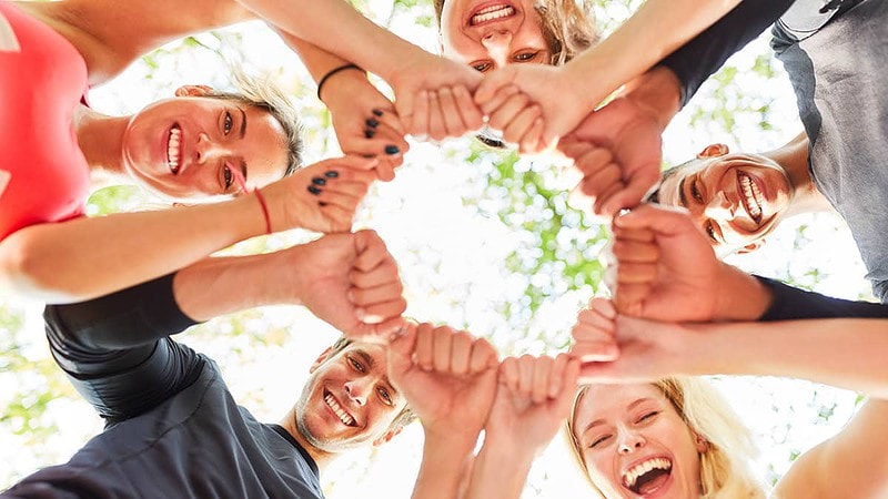 Gruppe im Kreis mit Händen in der Mitte