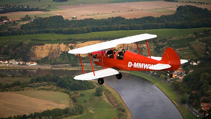 Ein rot-weißer Doppeldecker im Flug