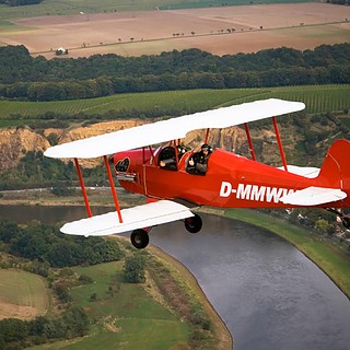 Roter Doppeldecker in der Luft beim Rundflug