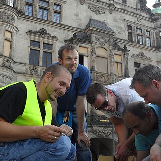 5 Männer schauen auf etwas beim Dresdner Schatzrundgang - Geocaching in historischem Ambiente