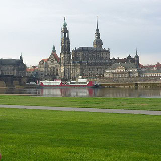 Mann hält Kompass am Dresden Elbufer bei der Team Challenge Schnitzeljagd