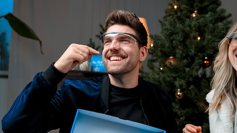 Ein Mann freut sich über eine Schutzbrille, die in der Geschenkbox war.