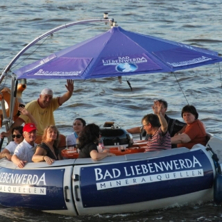 Leute fahren im Grillboot während der Tour Pizzafahrt in Dresden