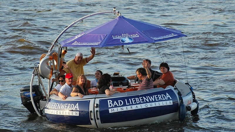 Leute fahren im Grillboot während der Tour Pizzafahrt in Dresden