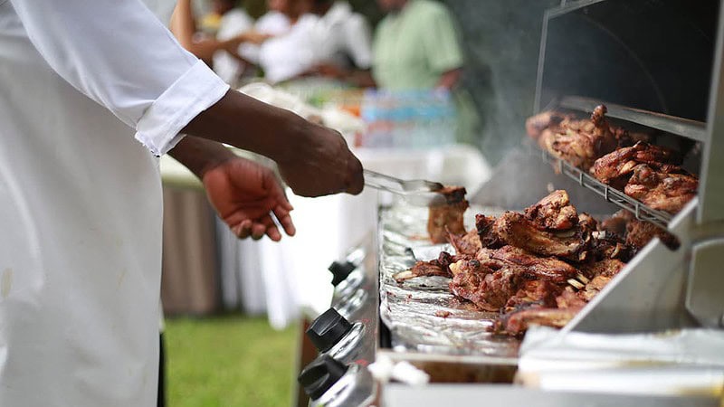 Der Koch grillt Fleisch auf einem Grill