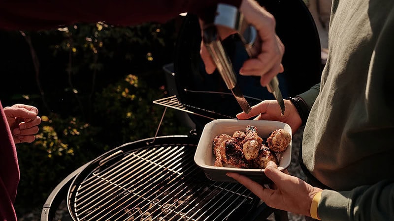 Zwei Personen haben Hähnchenoberkeule gegrillt