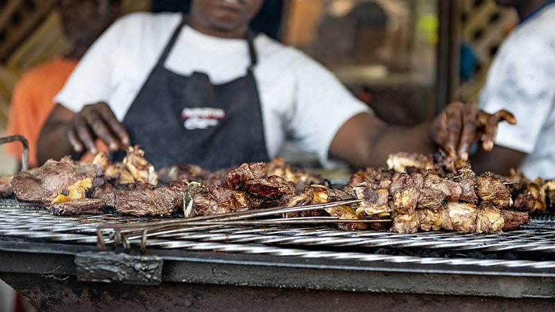 Ein Koch grill Fleisch auf einem Grill