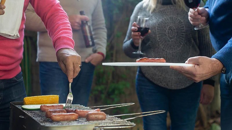 Die Freunde essen Fleisch und trinken Wein und Bier zusammen