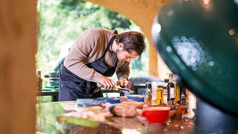 Ein Mann bereitet das gegrillte Essen vor