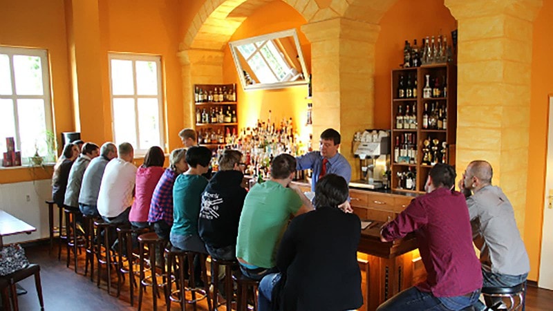 Viele Leute sitzen an der Bar beim Cocktail Aufbaukurs in Dresden