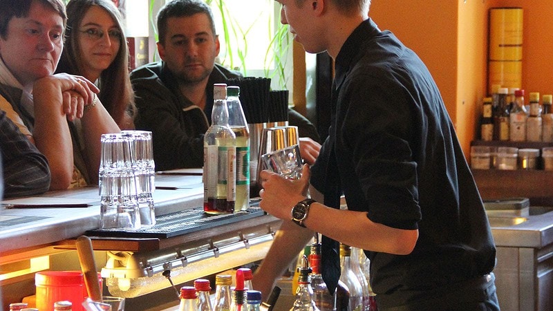 Barkeeper an der Bar vür Gästen des Cocktail Aufbaukurs in Dresden