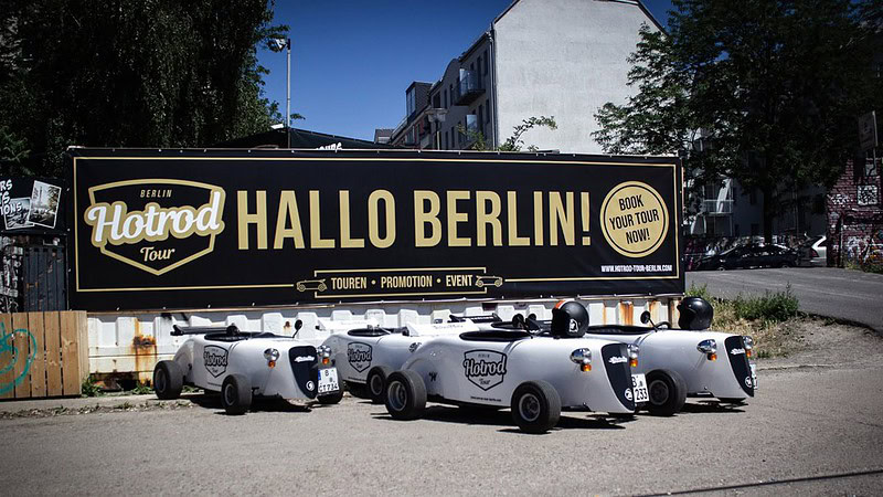 Autos stehen vor dem Logo - HotRod Tour in Berlin