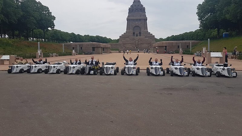 Hot Rod Tour Leipzig - HotRods vor dem Völerschlachtdenkmal mit Arm nach oben der Fahrer