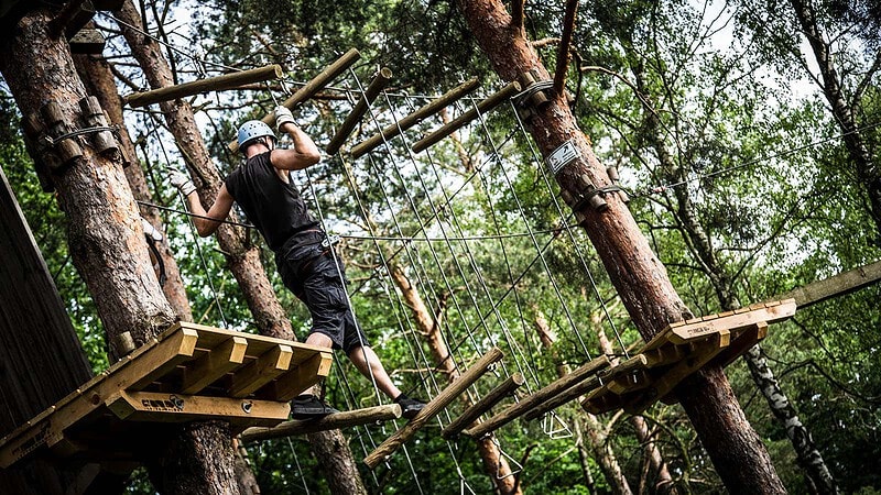 Mann klettert im Abenteuer Kletterwald bei Berlin