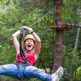 Frau fährt Seilbahn hinunter im Abenteuer Kletterwald bei Berlin