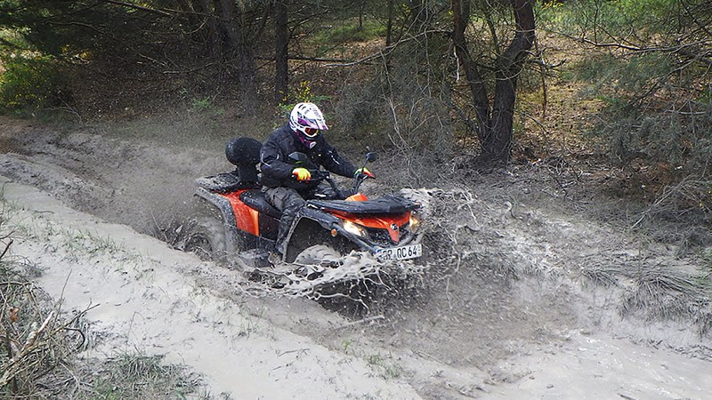 Ein quad mit einer Person durch den Matsch