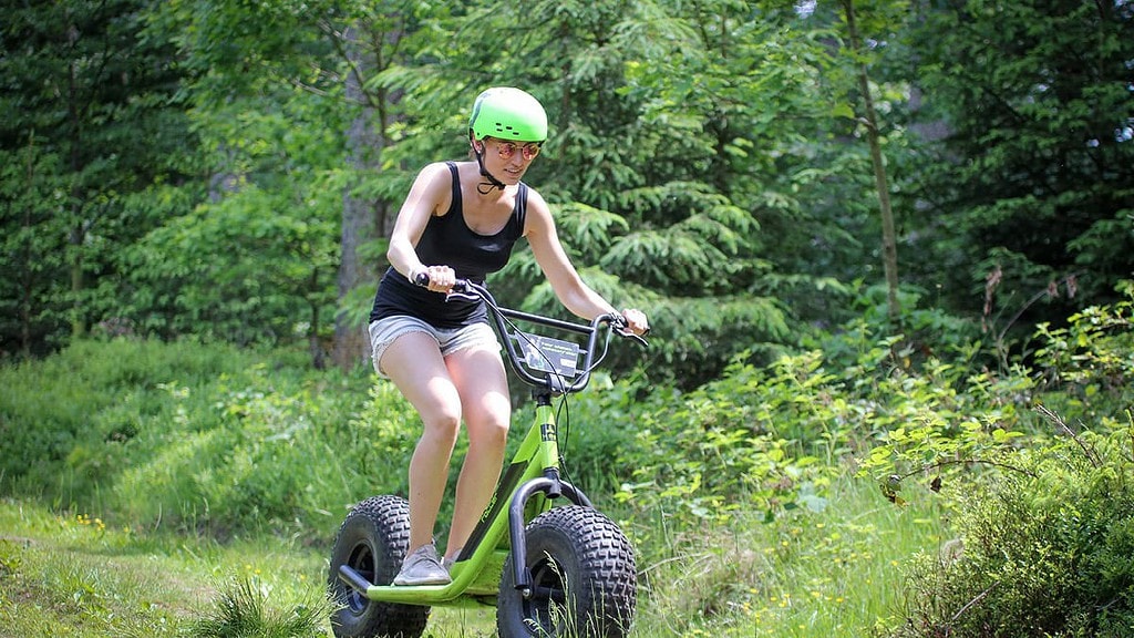 Frau fährt durch den Wald mit einem Monsterroller