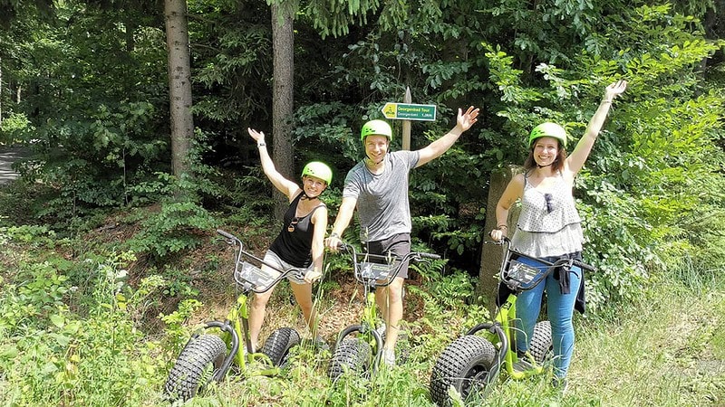 Monsterroller Tour Oberlausitz Personen mit Händen oben im Wald