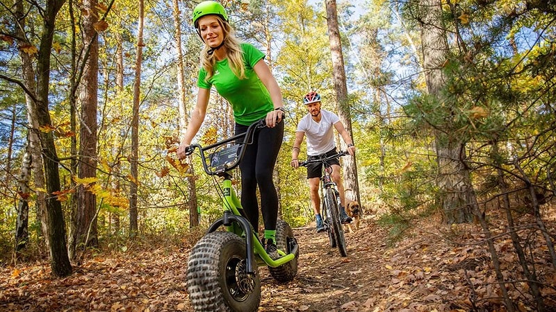 Mann fährt hinter Monterroller auf einem eBike hinterher