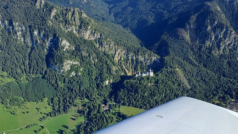 Schloss Neuschwanstein und die umliegenden Bergen aus der Vogelperspektive. - Rundflug im Sportflugzeug