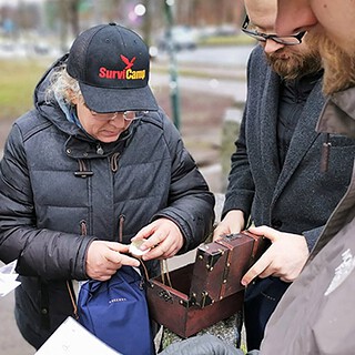 Kleine Gruppe mit kleiner Schatzkiste in der Hand.