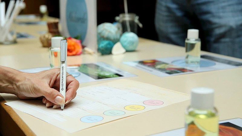 Person schreibt Duftmix als Rezeptur beim Parfum Workshop auf