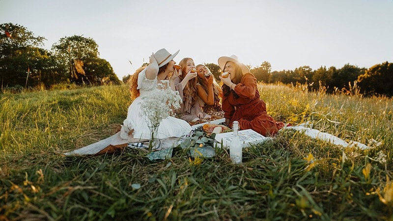 Vier Frauen genießen zusammen ein Picknick auf einer Wiese. - Picknick in Dresden