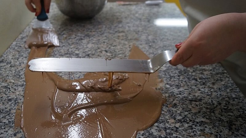 Schokolade verteilen auf einer Oberfläche für das Pralinenseminar in Dresden