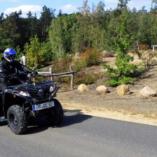 Ein Fahrer fährt mit einem Quad auf einer Straße.