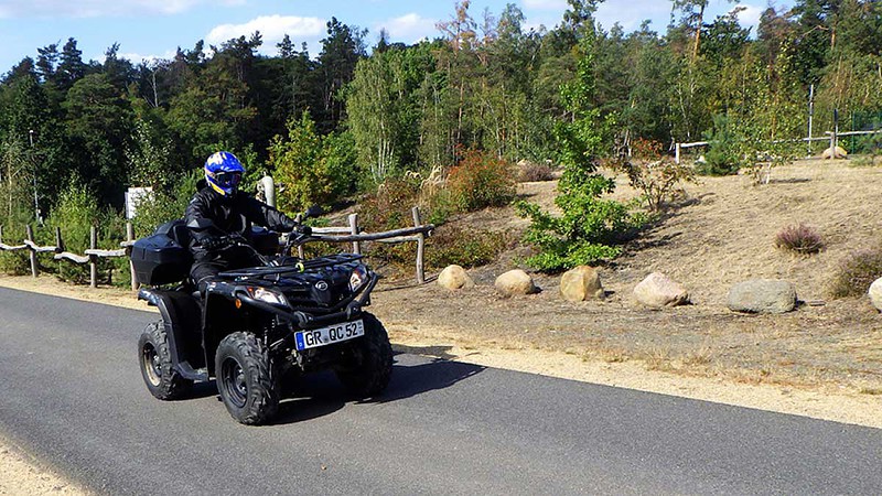 Ein Fahrer fährt mit einem Quad auf einer Straße.