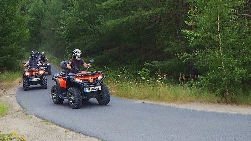 Eine Gruppe fährt mit dem Quad auf einer Straße bei Weißwasser.