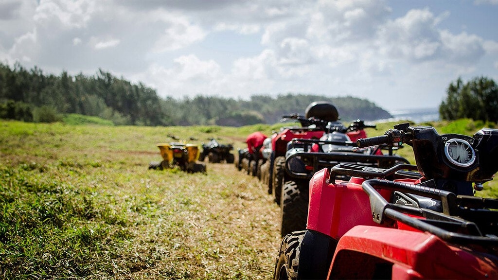 Mehrere Quads stehen auf einem Feld in einer Reihe.