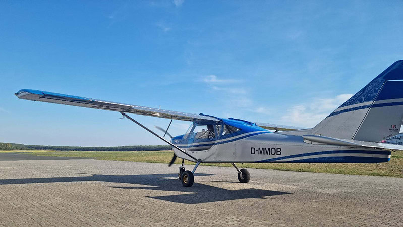 Ein kleines blaues Flugzeug auf einem Flugplatz