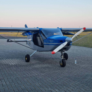 Ein kleines blaues Flugzeug auf einem Flugplatz