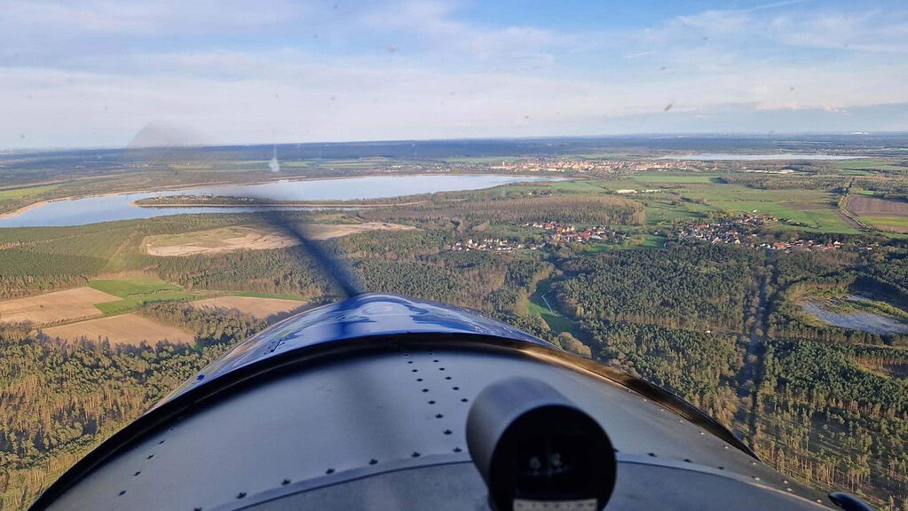 Blick aus dem Cockpit auf den Bug des Flugzeugs und auf die Felder - Rundflug bei Berlin