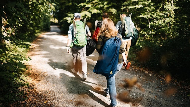 Schlauchboot mieten - Wanderung zum See mit Schlauchboot auf dem Rücken im Rucksack