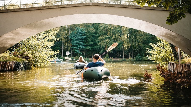 Schlauchboot mieten - Packraft auf dem Wasser unter einer Brücke