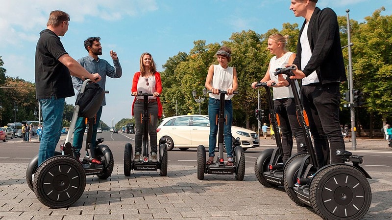 sechs Menschen stehen auf Segways im Kreis