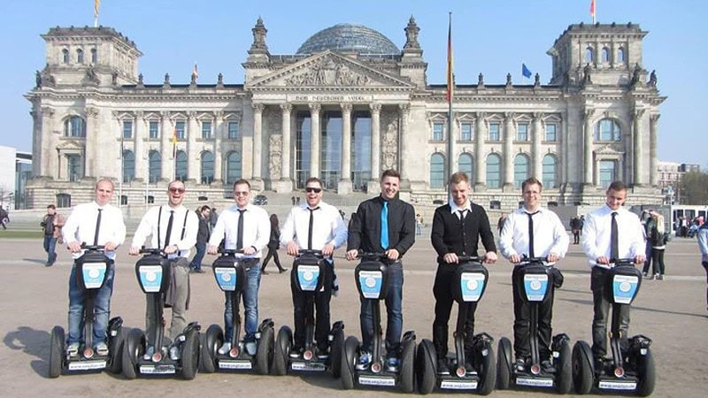 Männer stehen auf Segway vor dem Bundestag während der Segway Tour Auf den Spuren des dritten Reiches