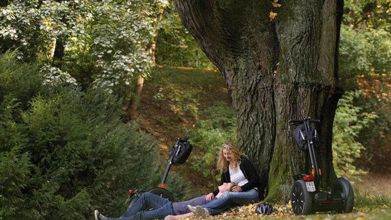 Segway und Frau steht vor Baum - wartend bei der Segway VIP Tour durch Berlin