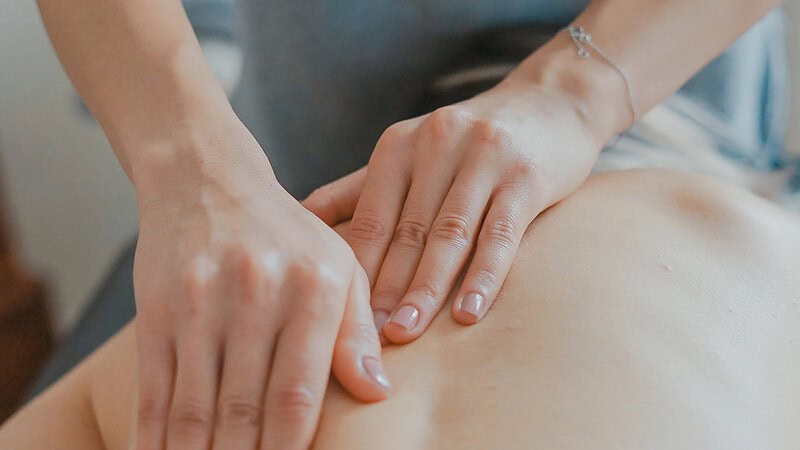 Hände massieren Rücken mit einer Lomi Lomi Massage in Chemnitz