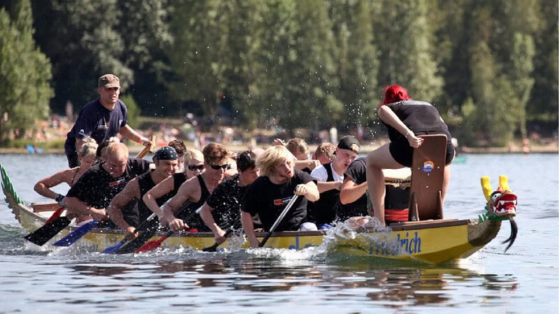 Gruppe von Menschen paddeln kräftig in einem Drachenboot