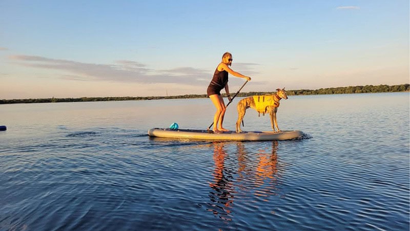 Frau mit Hund auf einem SUP