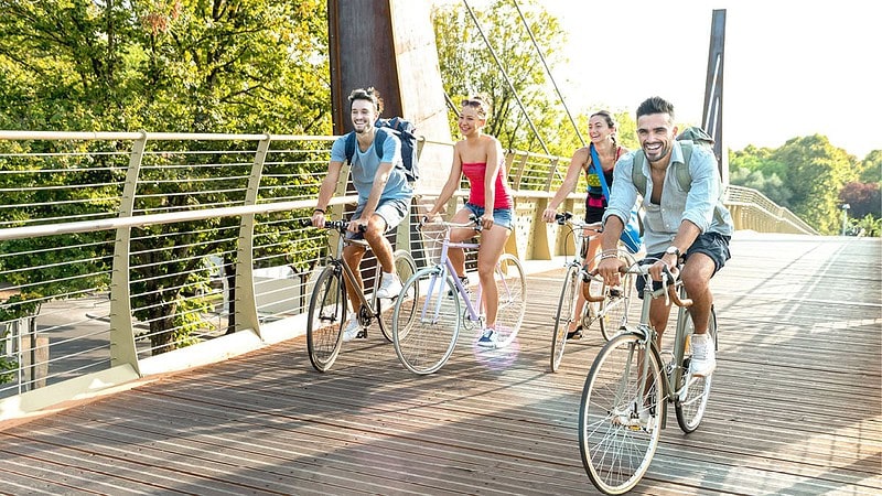 vier Menschen fahren über Brücke