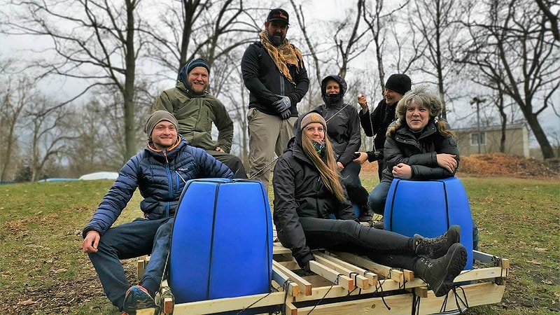 Team auf dem fertigen Floß auf der Wiese