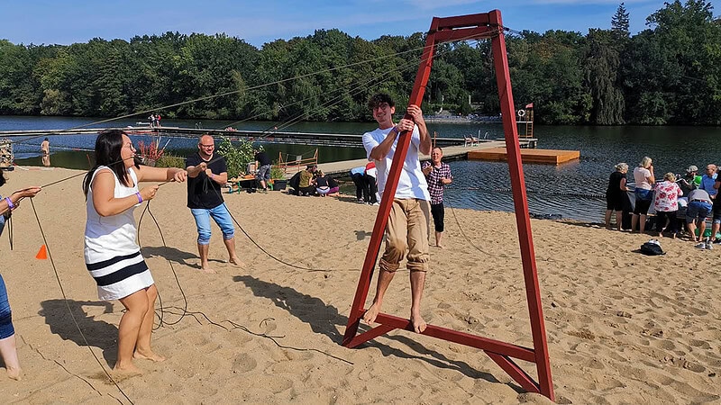 Team am Sandstrand beim Seilziehen